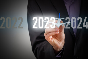 Finger pressing blue start 2023 button on virtual interface on gray background with copy space for text. Concept of new year. Businessman pressing 2023 start up business. Beginning of New Year 2023.