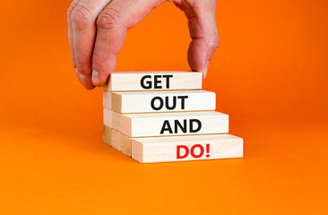 Motivational get out and do symbol. Concept words Get out and do on wooden cubes. Beautiful orange table orange background. Businessman hand. Business motivational get out and do concept. Copy space.