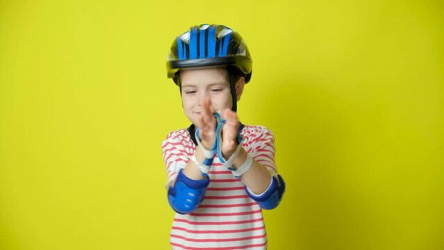 A boy in a helmet, elbow pads and gloves - protection when riding a bicycle, skateboard.