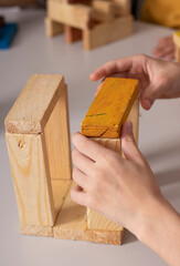 kids hands doing construction, wooden bricks puzzle