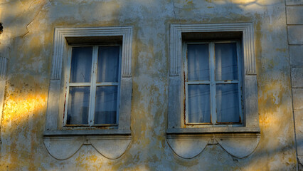 Fototapeta na wymiar Windows of an old house with yellow walls
