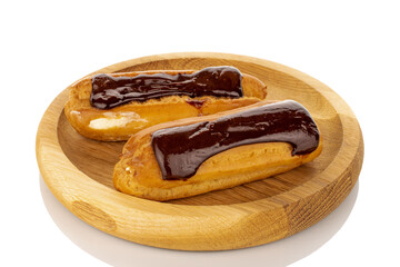 Two sweet chocolate eclairs on a wooden plate, macro, isolated on white background.