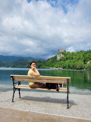 Person, tourist, happy woman walking near the lake Bled, enjoys view. Alps mountains. Slovenia travel. Summer vacation