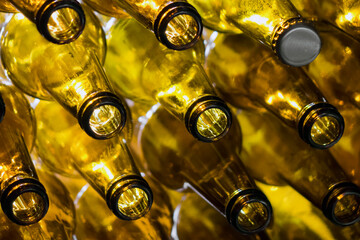 Yellow glass empty beer bottles lie in rows,Glass beer bottles lie in rows, necks on camera, shallow depth of sharp - 546352796