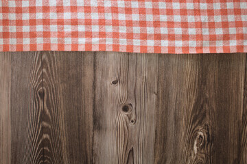 orange and white checkered tablecloth on wooden table background