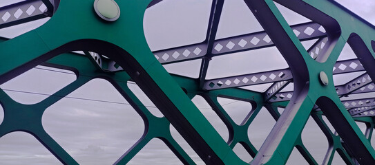 background, abstract, part of the bridge slabs, a green metal structure against a light sky