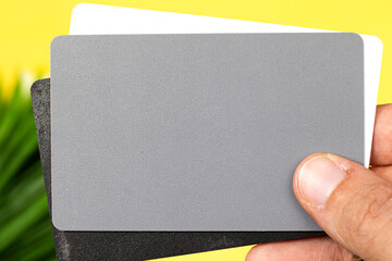 woman hand holding a grey card, a photographer’s tool, determining the correct white balance