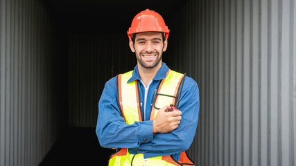 Engineer or foreman checking inventory or task details at container yard warehouse while wearing PPE., Logistics concept inside the shipping, import, and export industries.