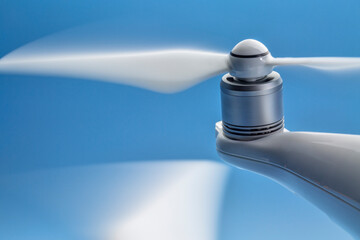 blurred spinning propeller of a quadcopter drone against blue sky