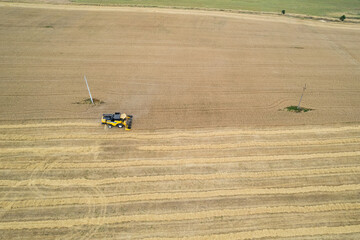 Harvesting machine working in the field. Top view from the drone Combine harvester agricultural...