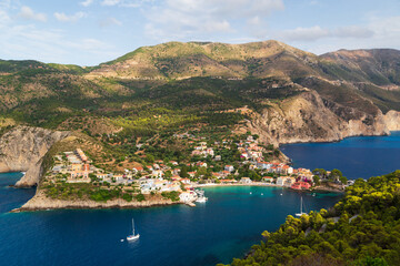 Naklejka na ściany i meble Fantastic top view at Asos village, Assos peninsula and blue Ionian Sea water. Aerial view, summer scenery of famous and extremely popular travel destination in Cephalonia, Greece, Europe.