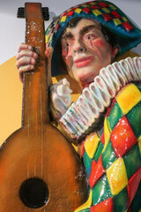 coloured harlequin playing an instrument