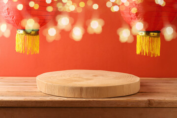 Festive background for Chinese New Year celebration with empty wooden log podium on table and...