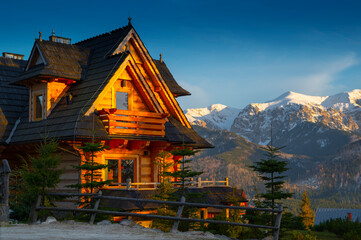 Obraz premium evening beautiful wooden house standing high in the mountains