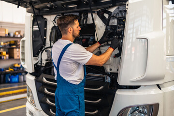 Professional truck mechanic working in vehicle repair service.