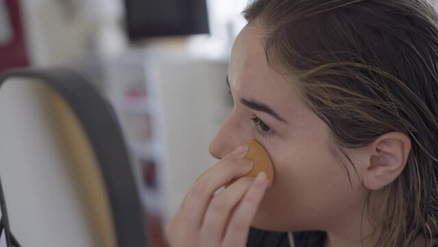 Close up on a woman adjusting her foundation. 