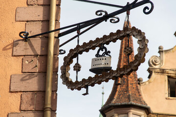 Fototapeta na wymiar Iron sign with an old iron and a church tower in the background
