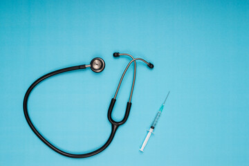 stethoscope, needle, vaccine standing on blue background
