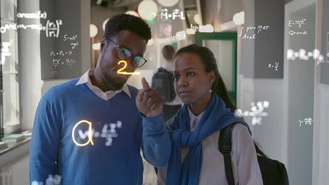 African-American teacher explain maths to talanted teen student drawing holographic formula in the air