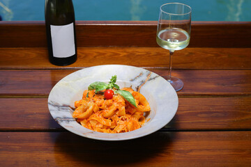 A plate of just cooked homemade fettuccine pasta with creamy tomato sauce, seafood and parmesan...