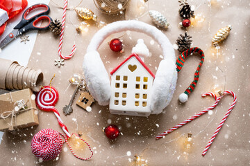 Key to the house with a keychain on a cozy home with a Christmas decor layout. A gift for New Year, Christmas. Building, design, project, moving to new house, mortgage, rent and purchase real estate