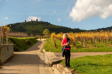 woman with msartphone hking in the vineyards
