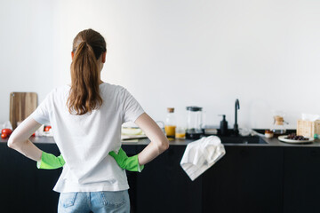 woman in kitchen with dirty countertop, kitchenware and utensils
