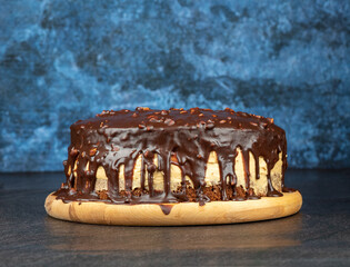 Homemade chocolate biscuit cake on a round cutting board.