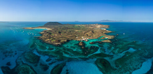 Mid level panoramic view of the natural pools and lagoons of Lobos island looking very tropical in the sunshine, El Puertito harbour near Corralejo Fuerteventura