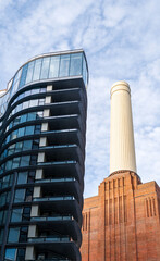 Low angle view at chimneys and brick facade of iconic London landmark Battersea Power Station and surrounding area.