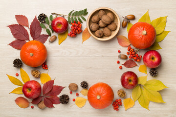 Festive autumn flat lay with pumpkins, berries and leaves on wooden background, top view
