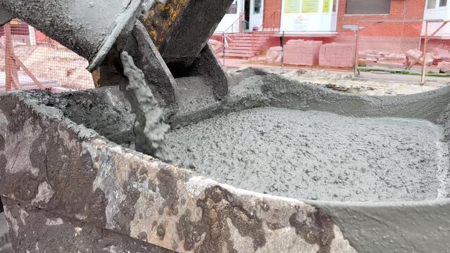 Cement flows from the concrete mixer 