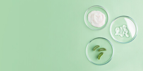 Photography from above of petri dishes with cosmetics gel in it and slices of aloe vera.Organic...