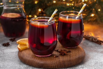 Two glasses of cherry mulled wine, gluhwein or glogg with cherry juice, orange, cinnamon, star...