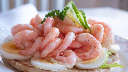 Close up of peeled fresh shrimps on white bread, making a delicious Swedish shrimp sandwich...