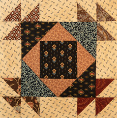 A basic quilt pattern sewn with decorative cotton fabric triangles, rectangles and squares.