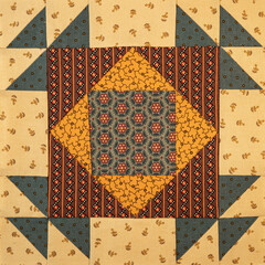 A basic quilt pattern sewn with decorative cotton fabric triangles, rectangles and squares.