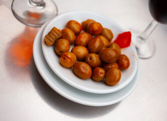 Plate with delicious pickled whole olives on dining table. Popular Spanish snack.