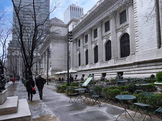 New York, NY - People walk among the bare trees in front of the New York Public Library main branch...