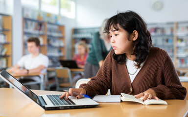 Asian girl with teenagers students studying in the school library