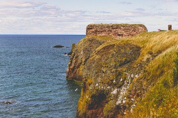 Scenic view of a rocky coastline and the blue calm sea of Dunbar, Scotland