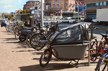 Many parked bikes and bicycles for rent on city street