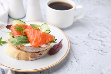 Tasty bruschetta with salmon, cucumbers and herbs on white textured table, closeup. Space for text