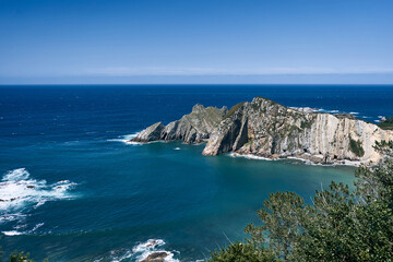 nice landscape of the cantabrian sea with different shades of blue and green near the big cliffs and the violent waves, asturias, spain