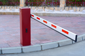 Closed boom barrier near road on autumn day outdoors