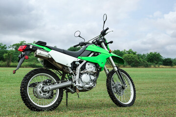 Obraz na płótnie Canvas Stylish cross motorcycle on green grass outdoors