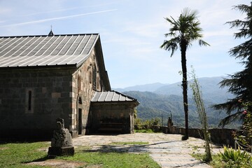 Fototapeta na wymiar Beautiful view of church, palm tree and mountains on sunny day