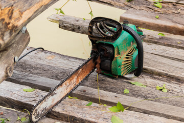 Chainsaw on wooden stump wide banner. Hard wood working in forest.