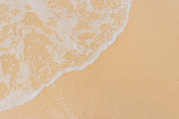 White soft waves of blue ocean on sandy beach for usage background and texture.