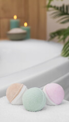 Colorful bath bombs on white towel in bathroom